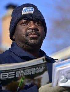 Tavis Weaver, 49, a veteran mail carrier with the U.S. Postal Service, delivers mail along Ohio Street on Friday morning.